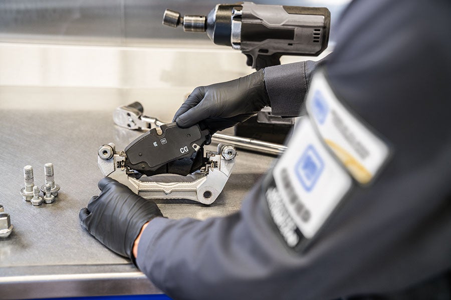 Technician installing a brake pad onto a caliper.