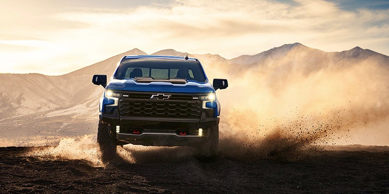 Front view of the 2025 Chevrolet Silverado driving up a dirt mountain road