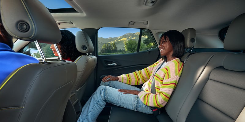 Interior view of the 2025 Chevy Trax's passenger row. There is a child in the backseat and two adults in the front seat..