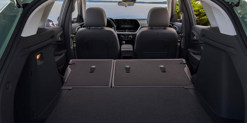 Rear interior view of the 2025 Chevy Trax. The trunk is open and two passenger seats are folded down for more cargo space.